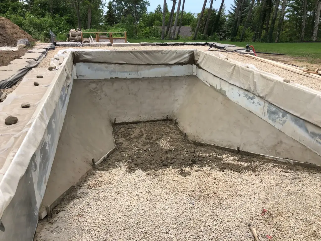 Structural shotcrete application for a custom inground pool foundation in Ontario, featuring reinforced steel mesh and precision gunite for maximum shell density.