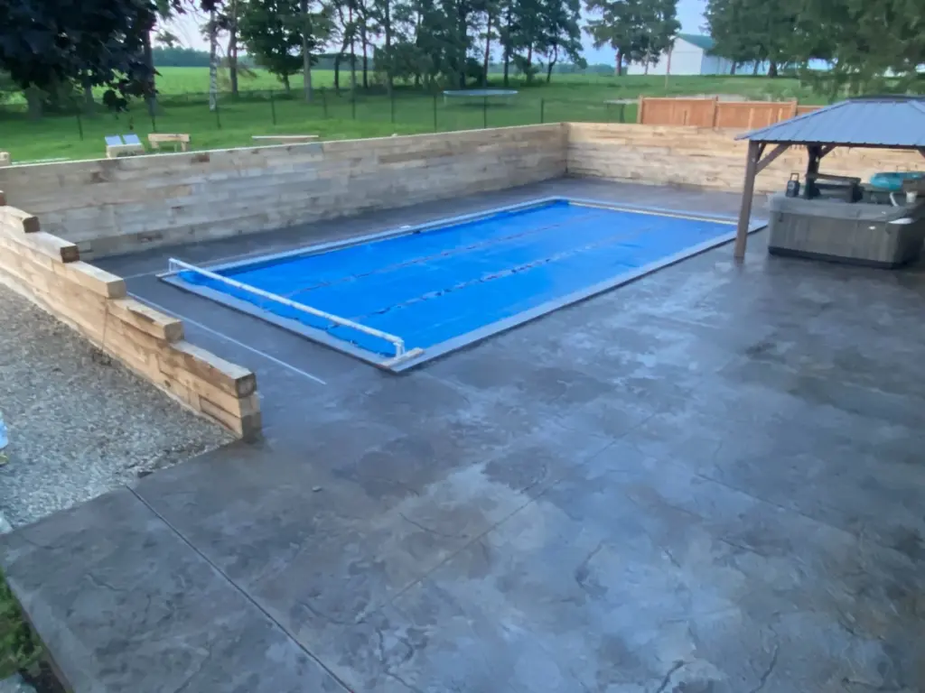 A finished luxury gunite pool in Ontario featuring custom shotcrete construction, integrated hardwood retaining wall, and a high-durability finish designed for the local climate.