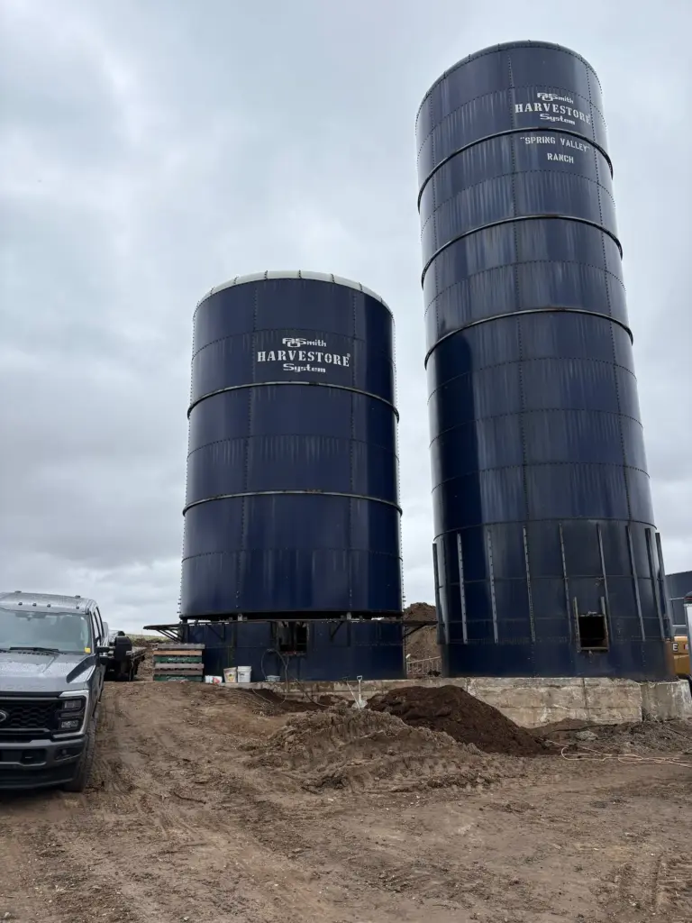 Tim Koch Construction crew performing a professional steel silo teardown and relocation in Shakespeare, Southwest Ontario, using a heavy-duty crane for agricultural infrastructure transport.